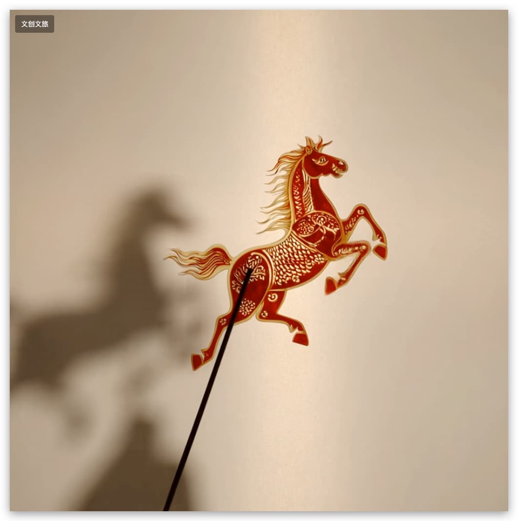 马年新春皮影非遗美学视频封面：暖檀棕主色背景上，朱红鎏金描边的奔马皮影在素白柔光幕布前扬蹄奔腾，展现传统雕刻工艺与光影艺术